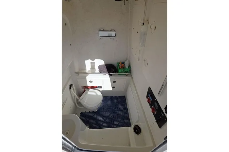 Slide: The Image of Interior of 2013 Sailfish 320 CC boat, featuring a compact marine toilet area. - 43