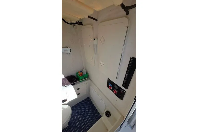 Slide: The Image of 2013 Sailfish 320 CC boat interior with storage compartments and control panel. - 46