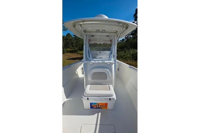 Slide: The Image of 2013 Sailfish 320 CC boat interior with seating and storage, under clear blue sky. - 47