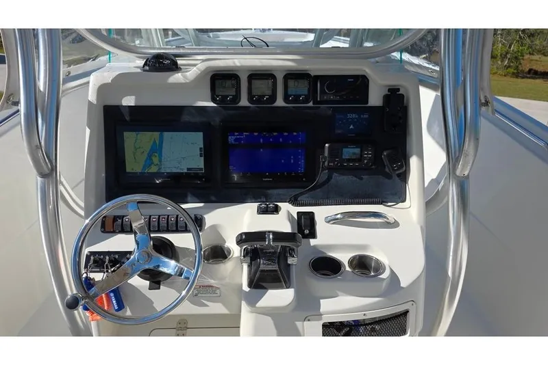 Slide: The Image of Control panel of a 2013 Sailfish 320 CC boat with navigation and communication equipment. - 49