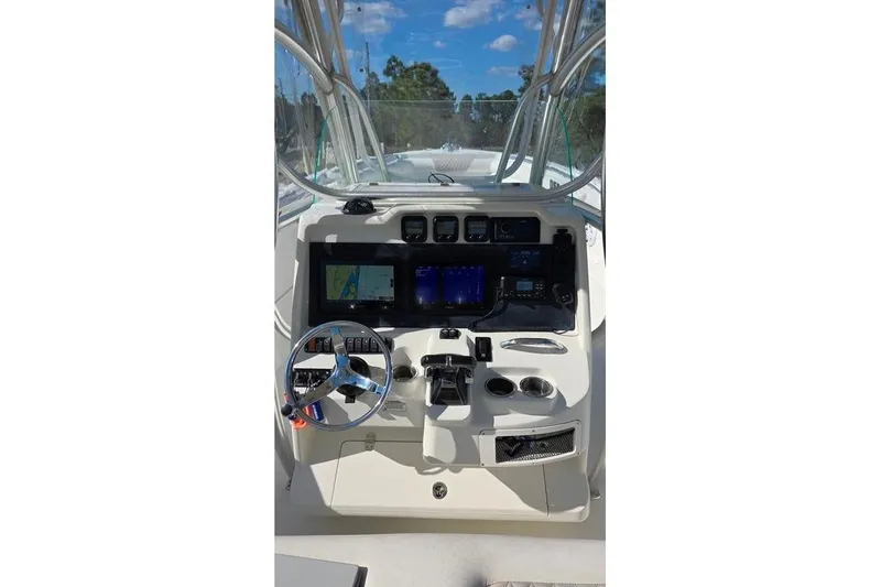 Slide: The Image of 2013 Sailfish 320 CC boat dashboard with steering wheel and navigation controls. - 50