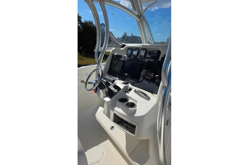Slide: The Image of 2013 Sailfish 320 CC boat console with steering wheel and navigation equipment. - 53
