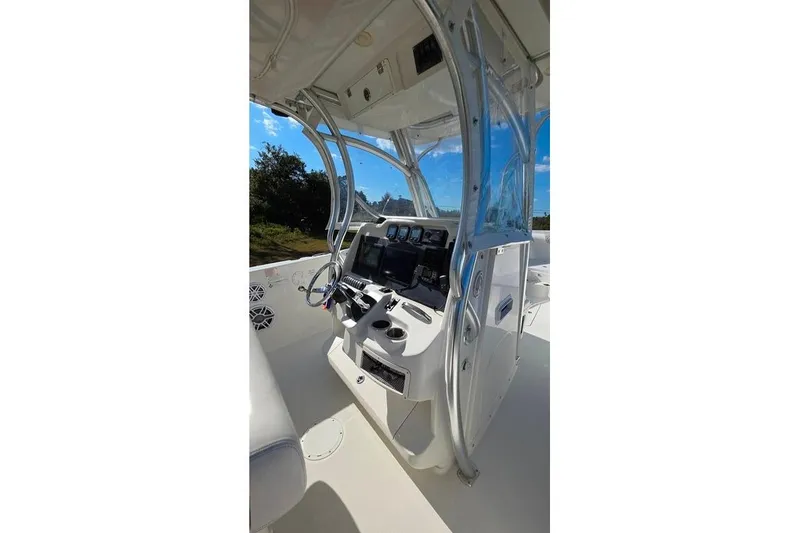 Slide: The Image of 2013 Sailfish 320 CC boat console with steering wheel and navigation equipment. - 54