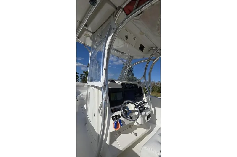 Slide: The Image of 2013 Sailfish 320 CC boat cockpit with steering wheel and navigation controls. - 57