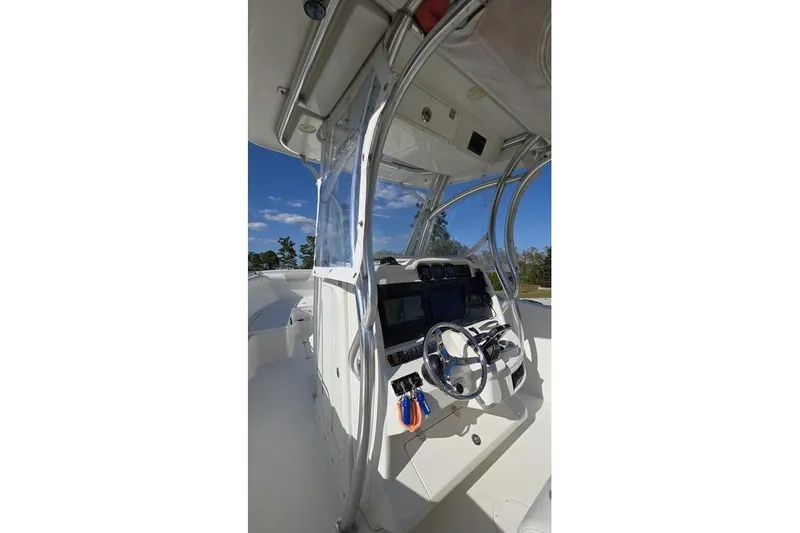 Slide: The Image of 2013 Sailfish 320 CC boat cockpit with steering wheel and navigation equipment. - 58