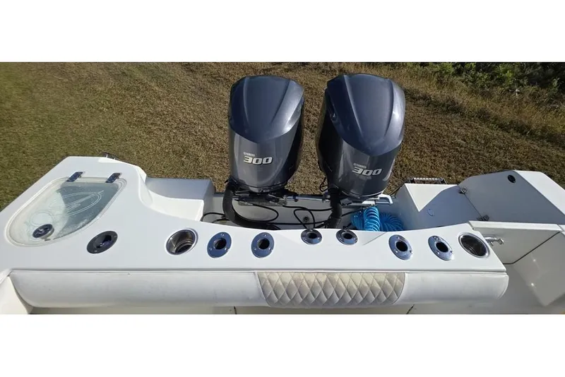 Slide: The Image of 2013 Sailfish 320 CC boat with dual 300 horsepower engines and fishing rod holders. - 60