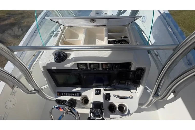 Slide: The Image of 2013 Sailfish 320 CC boat console with navigation equipment and storage compartments. - 62