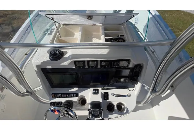 Slide: The Image of 2013 Sailfish 320 CC boat console with navigation controls and storage compartments. - 63