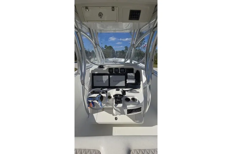 Slide: The Image of 2013 Sailfish 320 CC boat dashboard with Garmin navigation system and steering wheel. - 65