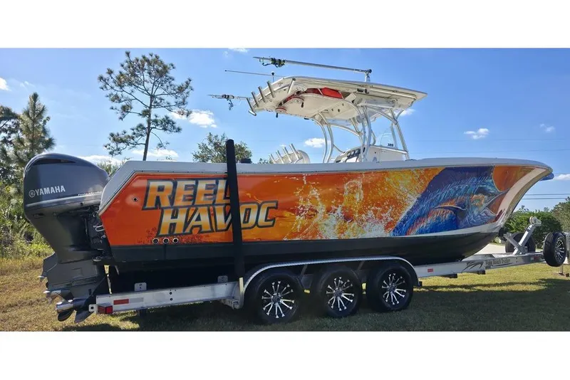 Slide: The Image of 2013 Sailfish 320 CC boat with vibrant "Reel Havoc" graphics on a trailer. - 7