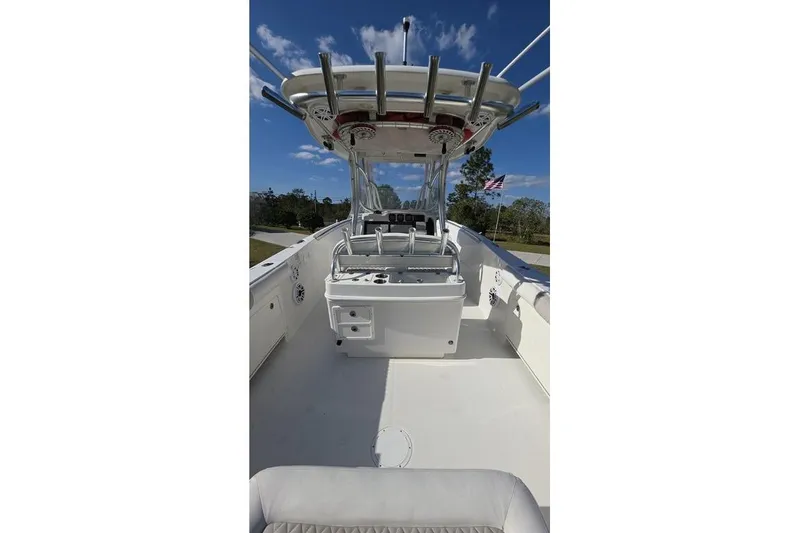 Slide: The Image of 2013 Sailfish 320 CC boat interior with helm, rod holders, and clear sky. - 70