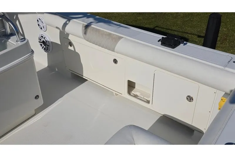 Slide: The Image of 2013 Sailfish 320 CC boat interior with storage compartments and speakers. - 76