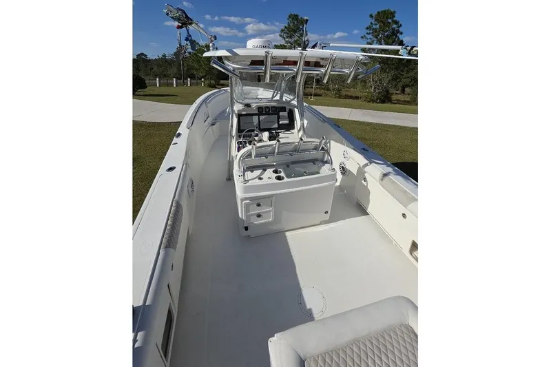 Slide: The Image of 2013 Sailfish 320 CC boat interior with helm, seating, and clear sky background. - 77