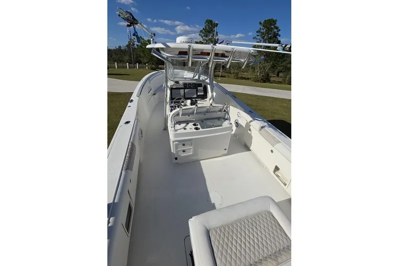 Slide: The Image of 2013 Sailfish 320 CC boat interior with helm and seating, under clear blue sky. - 78