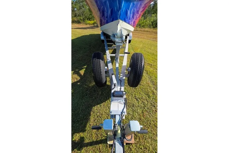 Slide: The Image of 2013 Sailfish 320 CC boat trailer on grassy field, viewed from front. - 79