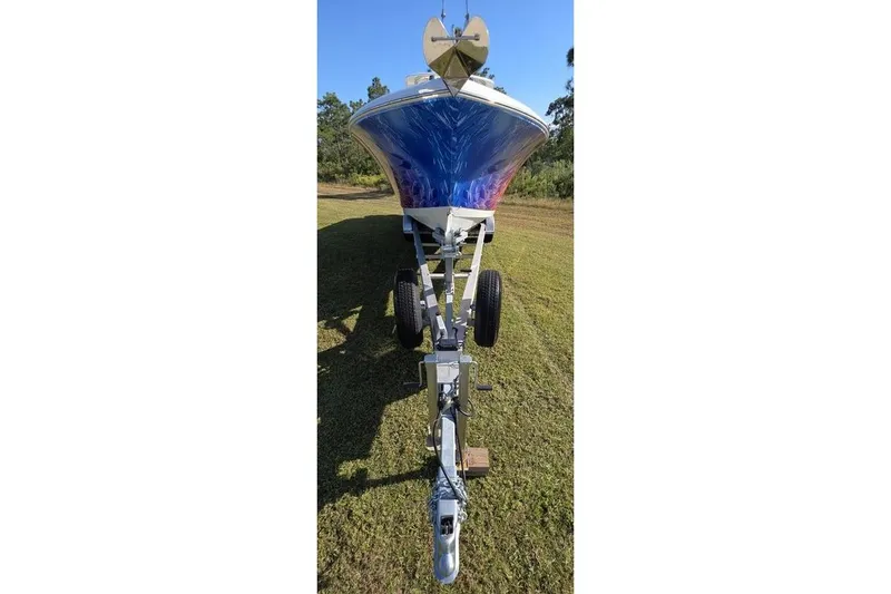 Slide: The Image of 2013 Sailfish 320 CC boat on trailer, parked on grassy area. - 80