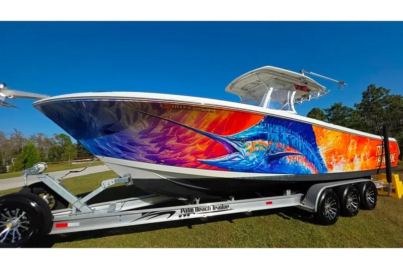 Slide: The Image of 2013 Sailfish 320 CC boat with vibrant marlin artwork on a trailer. - 84