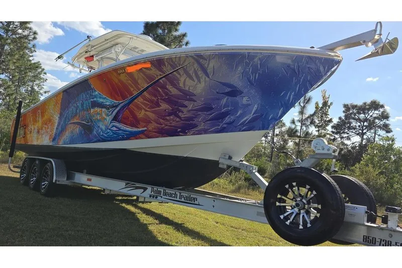 Slide: The Image of 2013 Sailfish 320 CC boat with vibrant marlin artwork on trailer. - 9