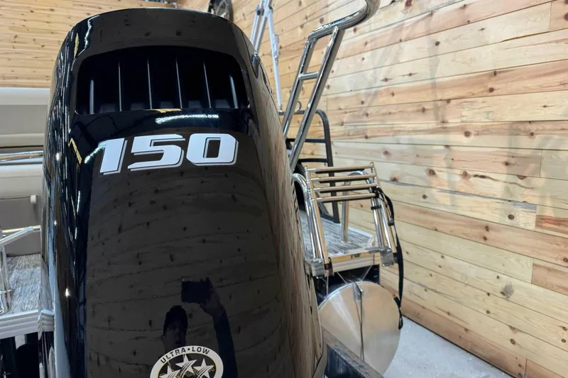 Slide: The Image of 2024 Crest Classic LX 220 SLSC boat with 150 horsepower engine in wooden interior setting. - 3