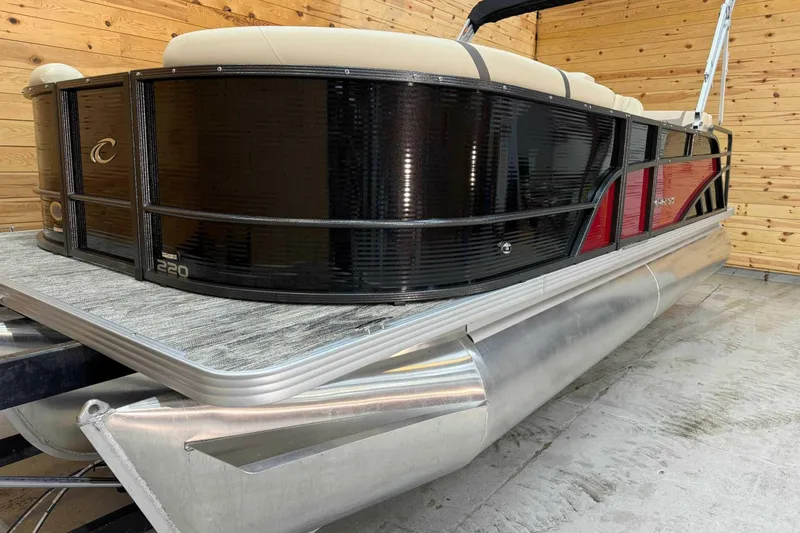 Slide: The Image of 2024 Crest Classic LX 220 SLSC pontoon boat in a wooden interior setting. - 4