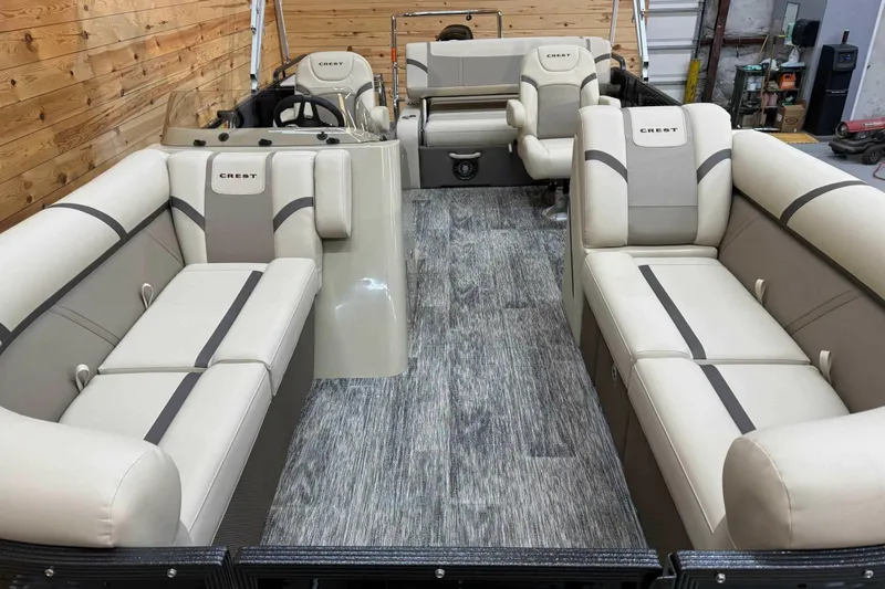 Slide: The Image of 2024 Crest Classic LX 220 SLSC pontoon boat interior with beige seating and wood accents. - 5