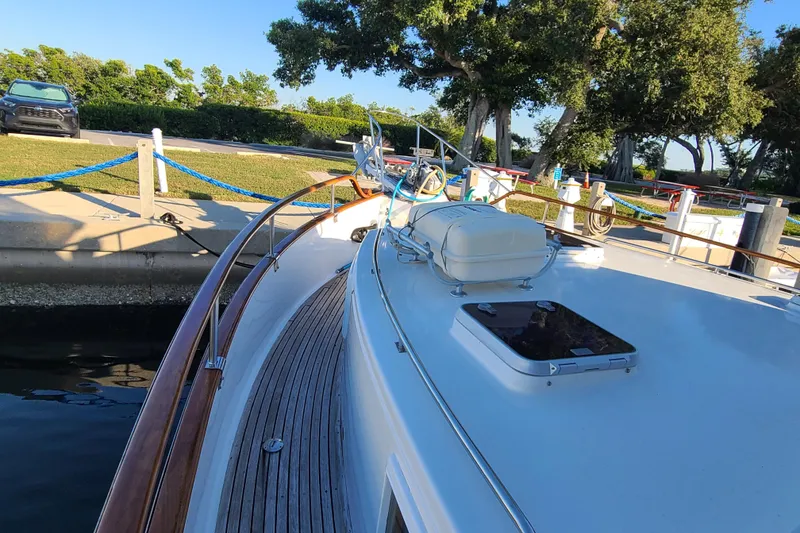 Slide: The Image of Grand Banks 46 Classic yacht docked, showcasing sleek deck design and polished wood railings. - 11
