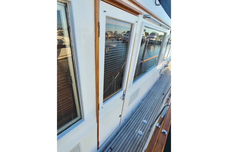 Slide: The Image of 2000 Grand Banks 46 Classic yacht with wooden deck and large windows. - 12
