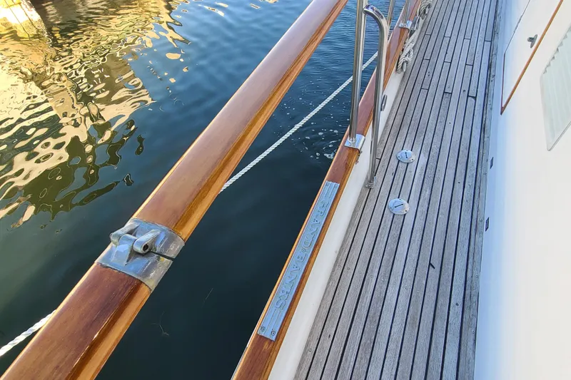 Slide: The Image of Deck view of 2000 Grand Banks 46 Classic yacht with wooden railings and water reflection. - 13