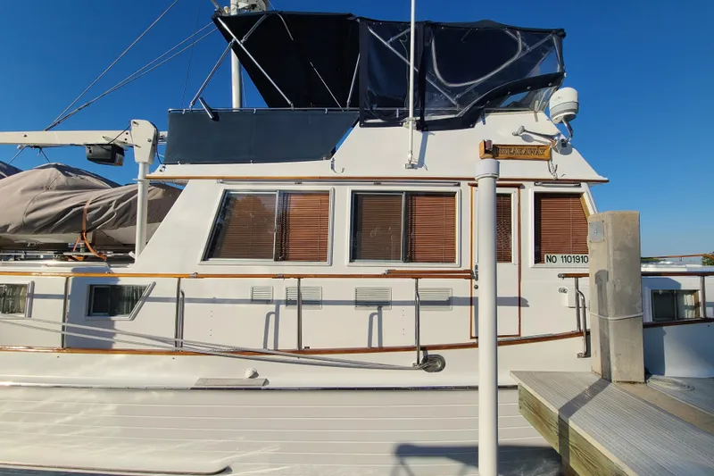 Slide: The Image of Grand Banks 46 Classic yacht, 2000 model, docked with blue canopy and wooden accents. - 5