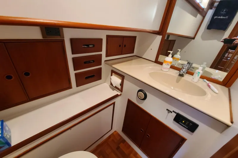 Slide: The Image of Bathroom interior of 2000 Grand Banks 46 Classic yacht with wooden cabinetry and sink. - 52