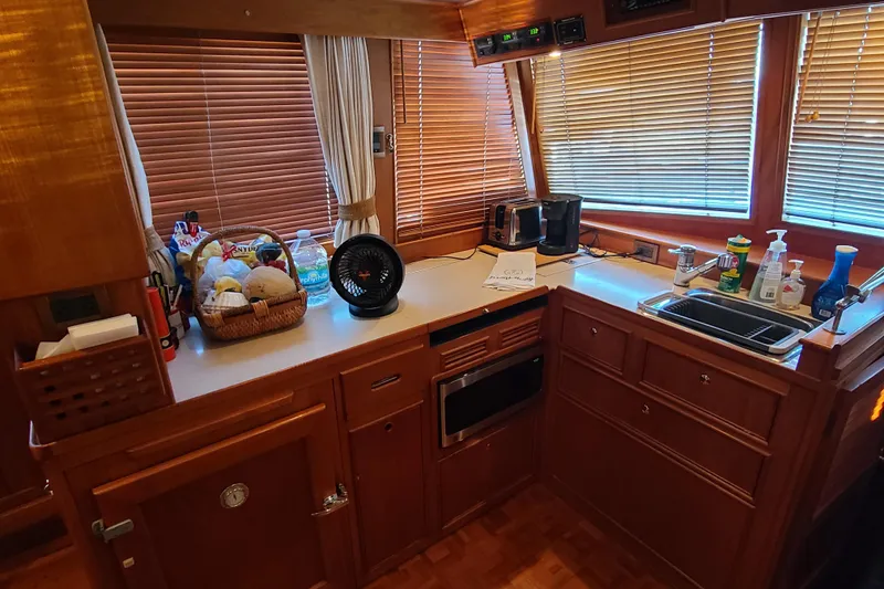 Slide: The Image of Kitchen area of 2000 Grand Banks 46 Classic yacht with wooden cabinetry and appliances. - 69