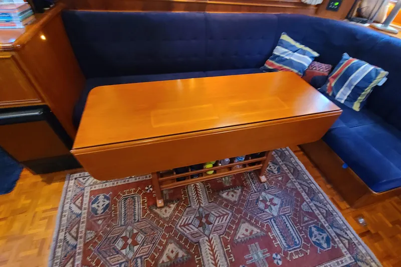 Slide: The Image of Interior of 2000 Grand Banks 46 Classic with wooden table, blue seating, and patterned rug. - 74