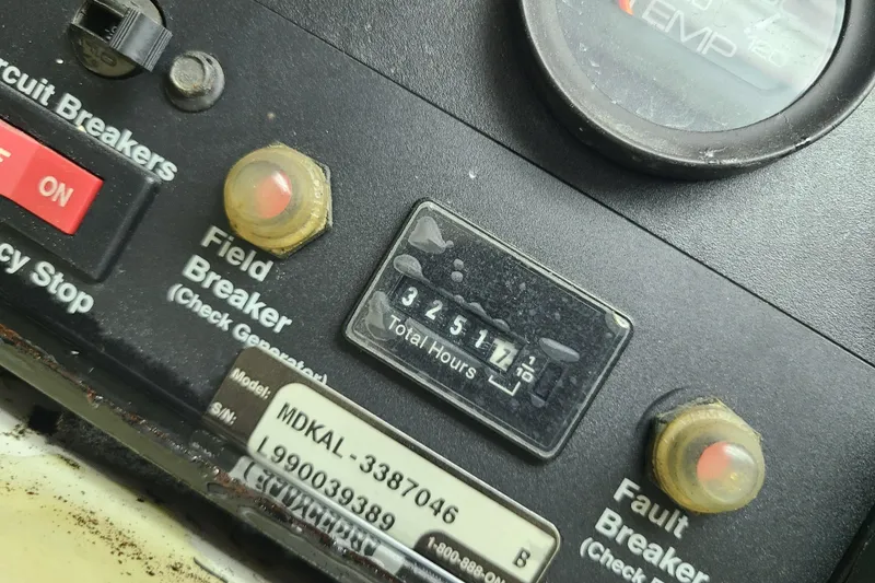 Slide: The Image of Control panel of a 2000 Grand Banks 46 Classic boat showing circuit breakers and hour meter. - 85
