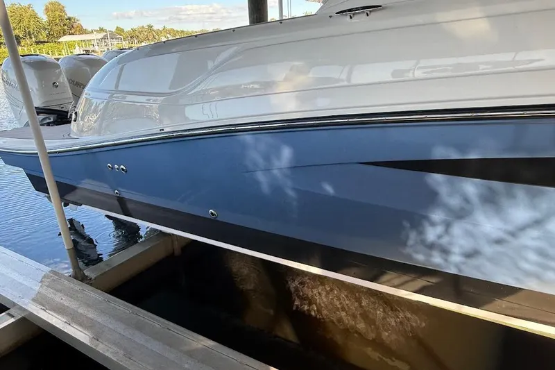Slide: The Image of 2018 Sae Ray 38SLV OB boat docked, featuring sleek blue and white design. - 10