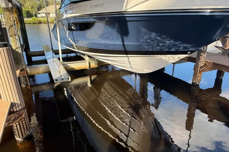 Slide: The Image of 2018 Sae Ray 38SLV OB boat docked above water, reflecting on calm surface. - 12
