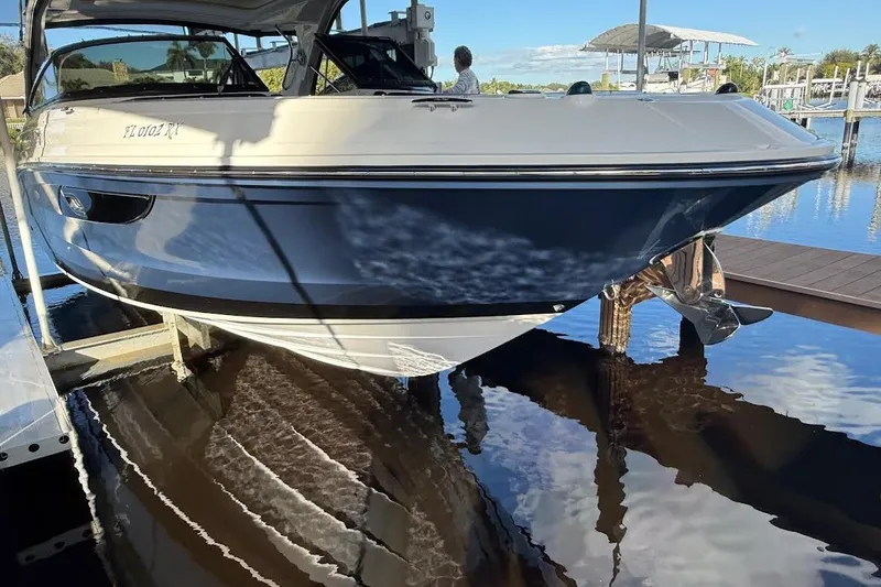 Slide: The Image of 2018 Sae Ray 38SLV OB boat docked on calm water, reflecting clear blue sky. - 2