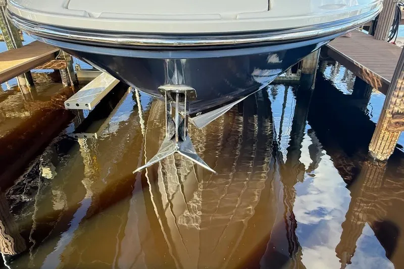 Slide: The Image of 2018 Sae Ray 38SLV OB boat docked with anchor visible in water. - 54