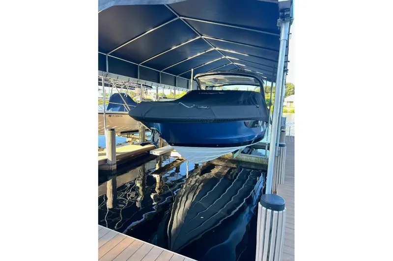 Slide: The Image of 2018 Sae Ray 38SLV OB boat docked under a covered marina. - 59