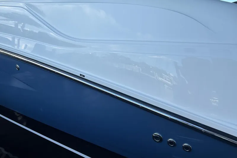 Slide: The Image of 2018 Sae Ray 38SLV OB boat hull, sleek design with blue and white finish. - 6