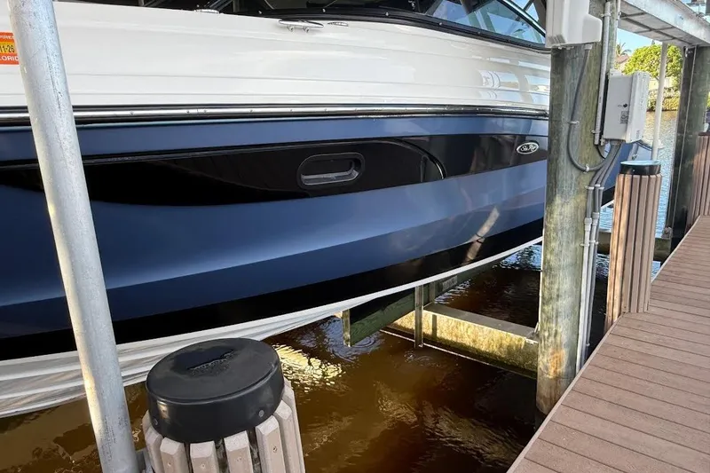 Slide: The Image of 2018 Sae Ray 38SLV OB boat docked on a lift by a wooden pier. - 8