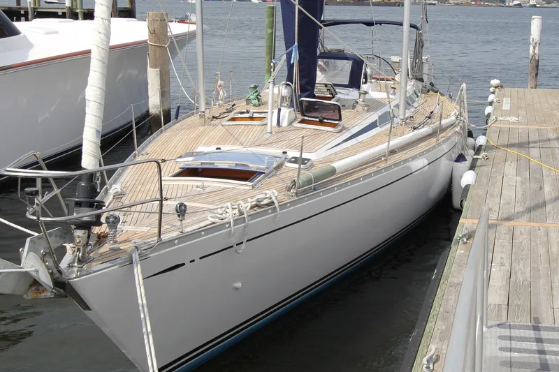 Slide: The Image of 1989 Nautor Swan 53 yacht docked, showcasing sleek design and wooden deck. - 2