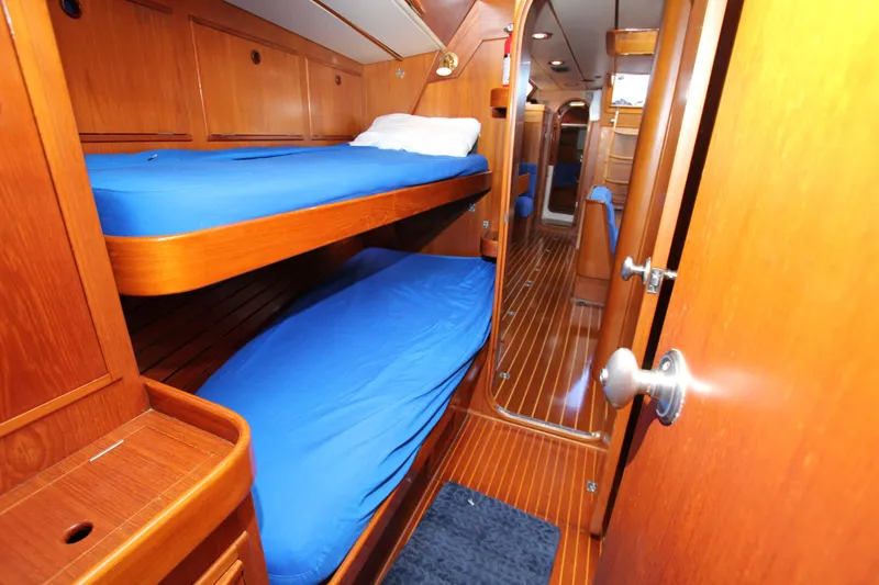 Slide: The Image of Interior of 1989 Nautor Swan 53 yacht with wooden bunk beds and blue bedding. - 26