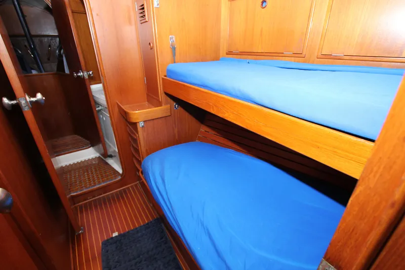 Slide: The Image of Interior of 1989 Nautor Swan 53 yacht with wooden bunk beds and blue bedding. - 27