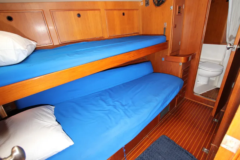 Slide: The Image of Interior of 1989 Nautor Swan 53 yacht with wooden bunk beds and adjacent bathroom. - 29