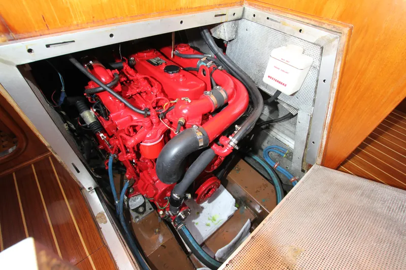 Slide: The Image of Engine compartment of 1989 Nautor Swan 53 yacht, featuring a red engine and wooden flooring. - 41