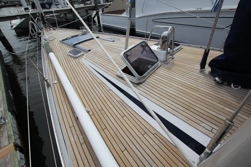 Slide: The Image of Teak deck of 1989 Nautor Swan 53 sailboat, featuring sleek design and open hatches. - 5