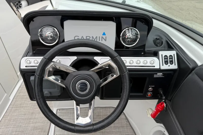 Slide: The Image of 2022 Crownline 255 SS boat dashboard with Garmin display and steering wheel. - 11