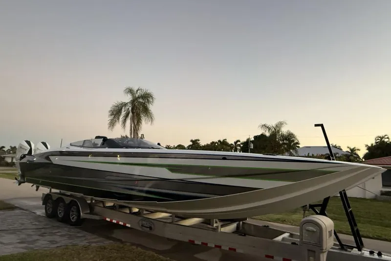 The Image of 2025 Nor-Tech 4000 Roadster boat in warehouse, on trailer, with green accents. - 1