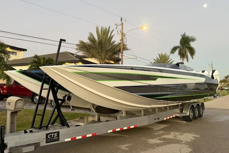 Slide: The Image of 2026 Nor-Tech 4000 Roadster powerboat on trailer, sleek design with green accents, parked roadside. - 3