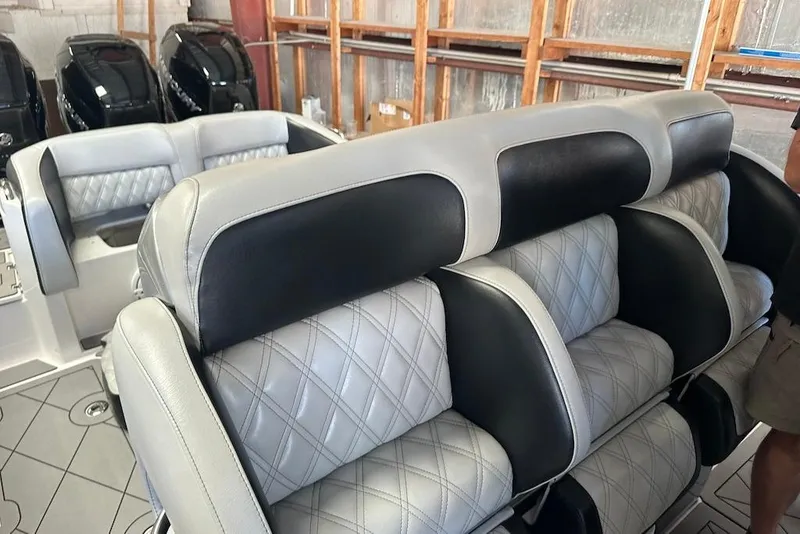 Slide: The Image of 2017 Nor-Tech 340 Sport Center Console boat interior with luxurious seating and powerful engines. - 16